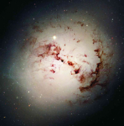 A galáxia elíptica gigante NGC1316, ou Fornax A, tal como vista pelo telescópio espacial Hubble. Apesar de aparentemente estável, esta galáxia formou-se a partir da colisão entre duas galáxias espirais, há alguns milhares de milhões de anos, um acontecimento que poderá estar na origem de outras galáxias elípticas. Cortesia: NASA, ESA, The Hubble Heritage Team (STScI/AURA), P. Goudfrooij (STScI) e colaboradores.
